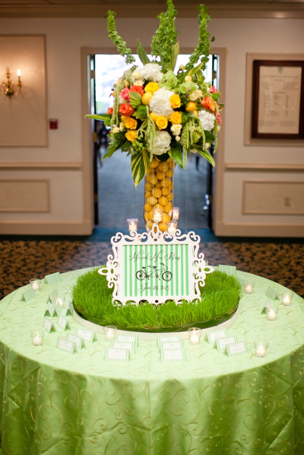 A unique summer arrangement was designed for the escort table and included submerged lemons, a base of green trick and a custom sign