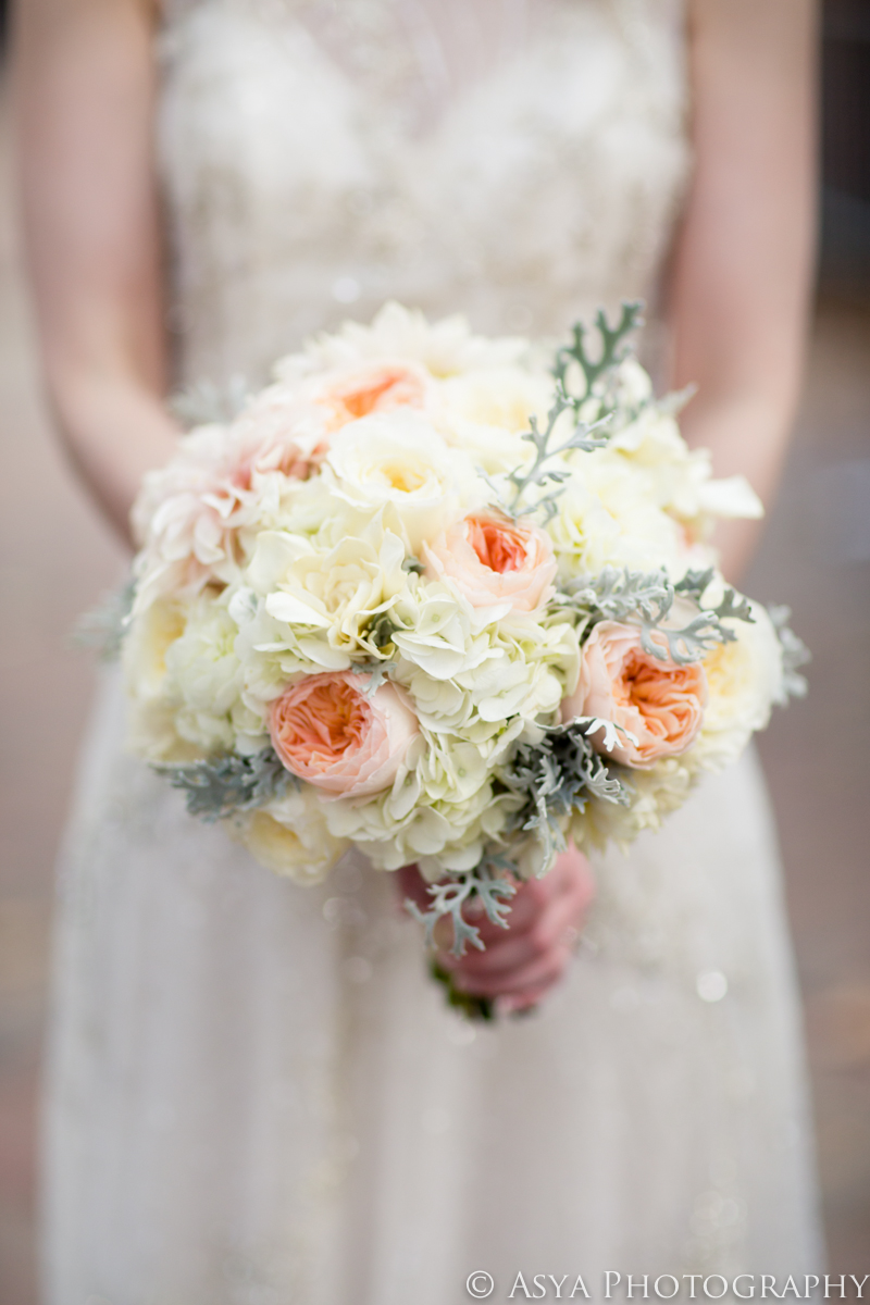 A bridal bouquet of whute hydrangea, pink garden roses and soft dusty miller foliage