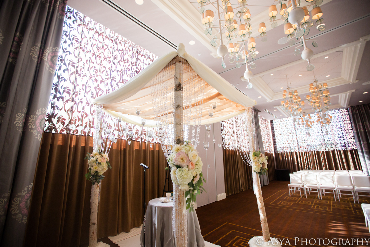 Custom chuppah draped in sheer white with floral clusters and crystal beading
