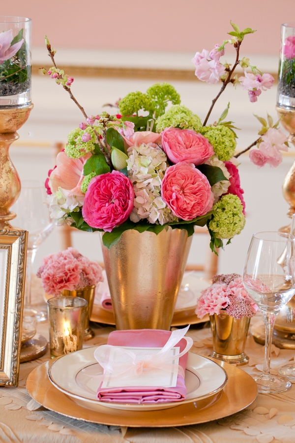 Pink garden roses and green hydrangea fill a gold vase as part of a more elaborate tablescape