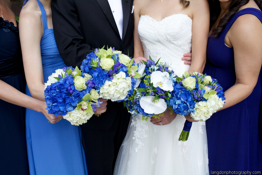 The bridal party with coordinating blue, white and green floral bouquets. The bride's bouquet was accented with white phalaenopsis orchids and a crystal pin.