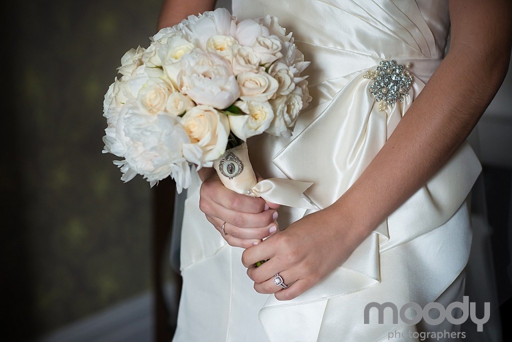 A cameo provided a unique personal touch to the bride's bouquet of white peonies and roses.