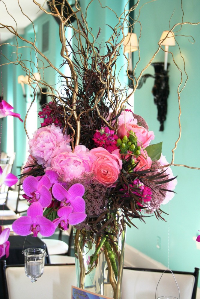 tall centerpiece of pink flowers and branches 