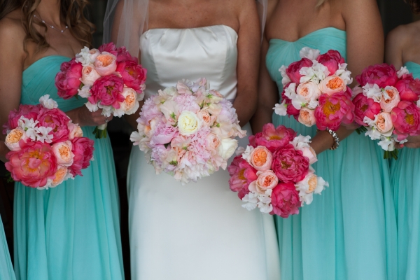 The bridal party wore a sea-inspired color palette of turquoise blue, coral flowers and  soft whites.